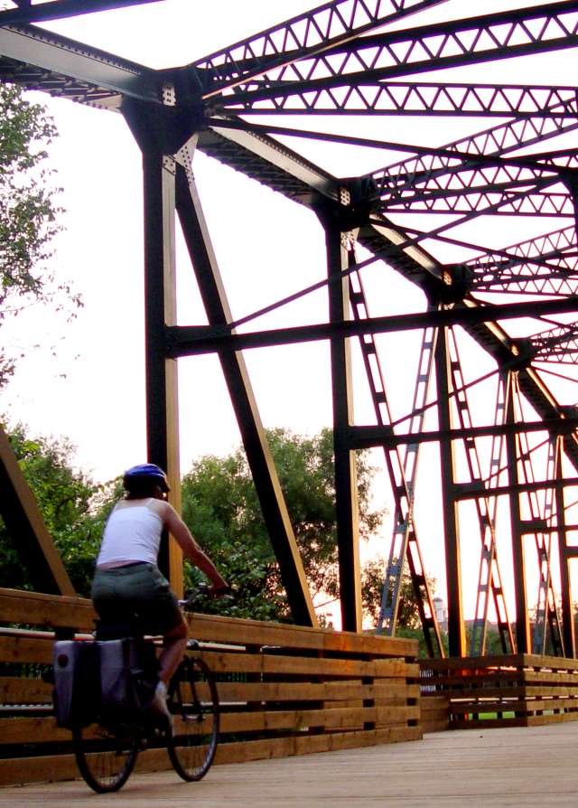 People and Biker Crossing Bridge